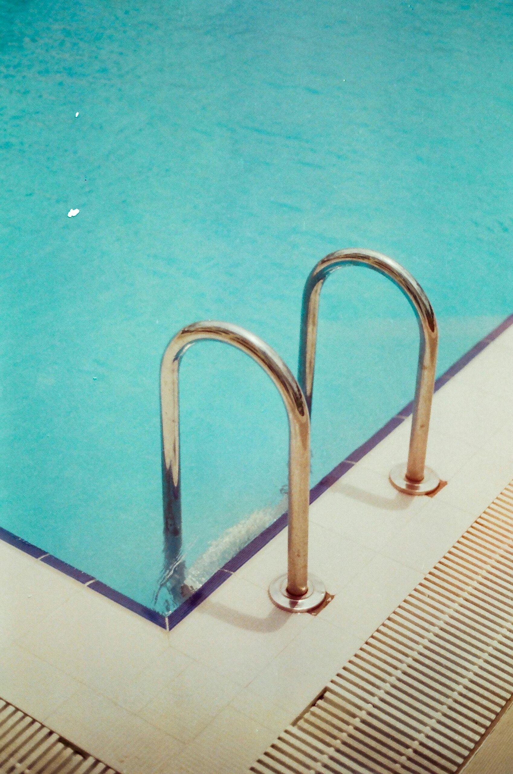 Simple poolside view featuring metal handrails and shimmering water.